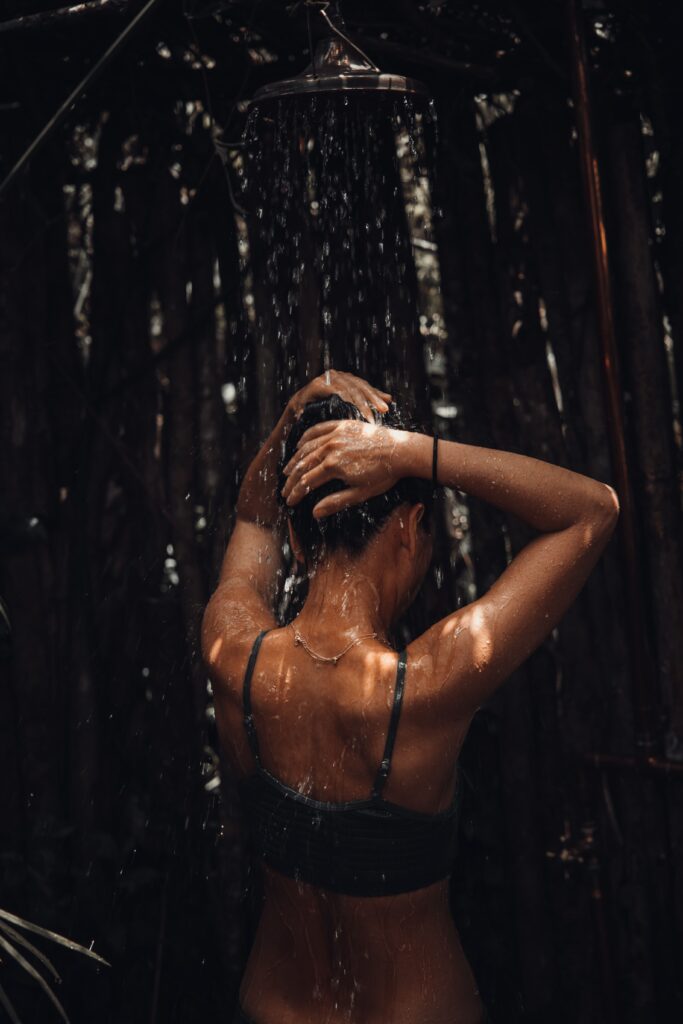 Femme sous une douche extérieure