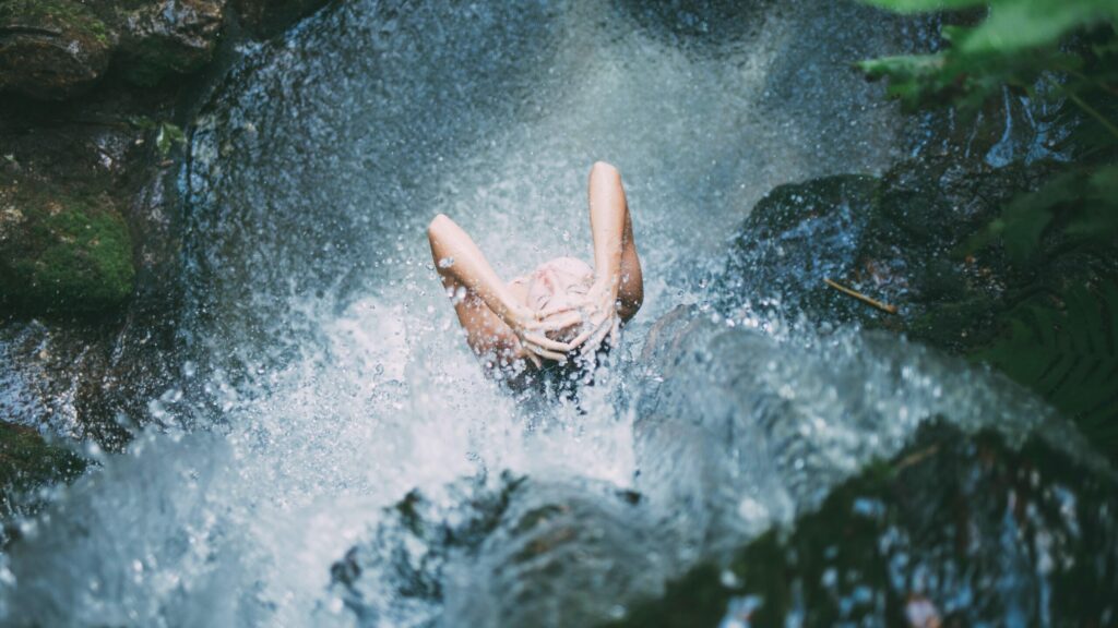 Femme sous une cascade
