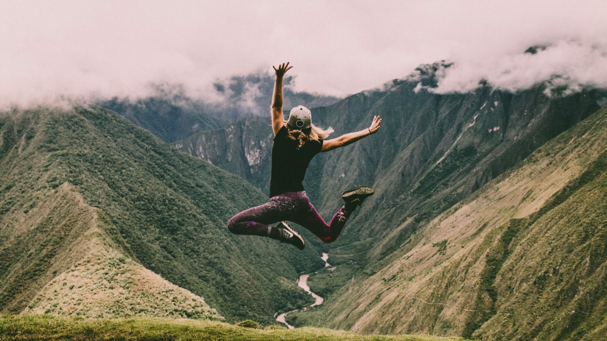 Femme qui saute de joie dans la montagne