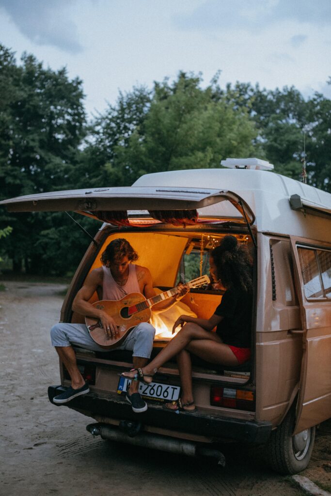 Un homme et une femme jouant de la guitare à l'arrière d'un van
