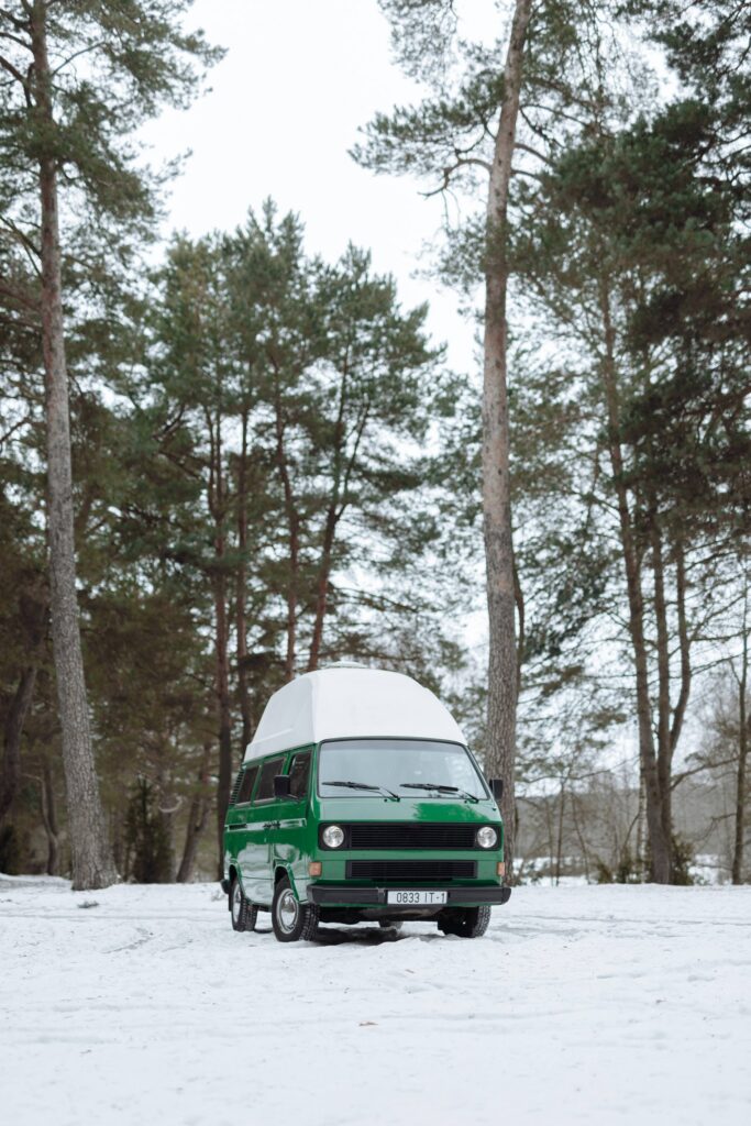Van vert sous la neige dans la forêt